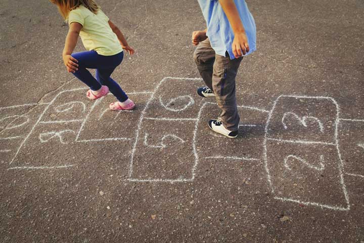 Child and parent playing hopscotch