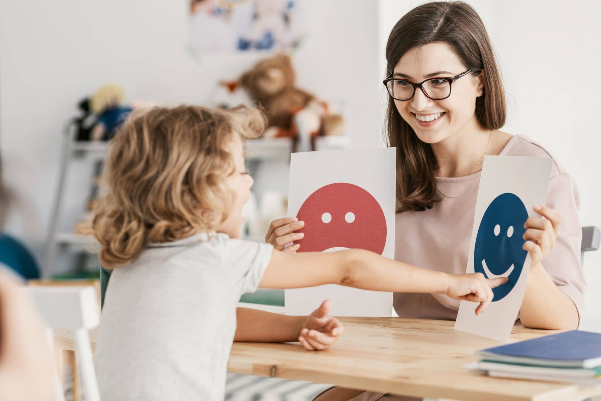 Young child pointing out emotions on cards