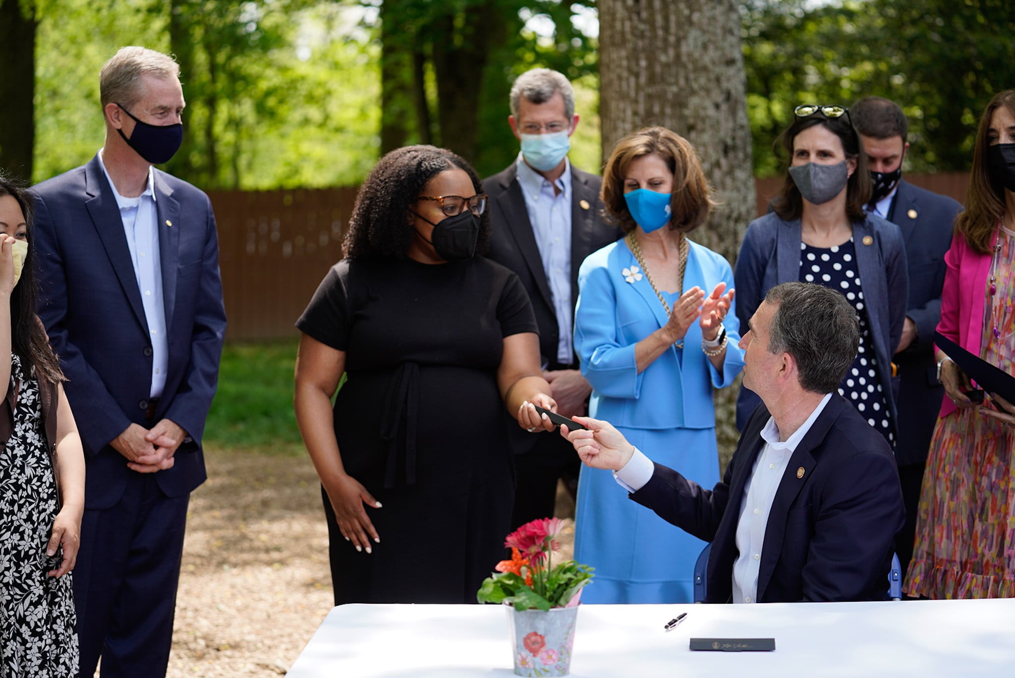 Gov Northam hands a pen to center director after signing HB2206 (Filler-Corn) expanding childcare access in April 2021 in Burke, VA