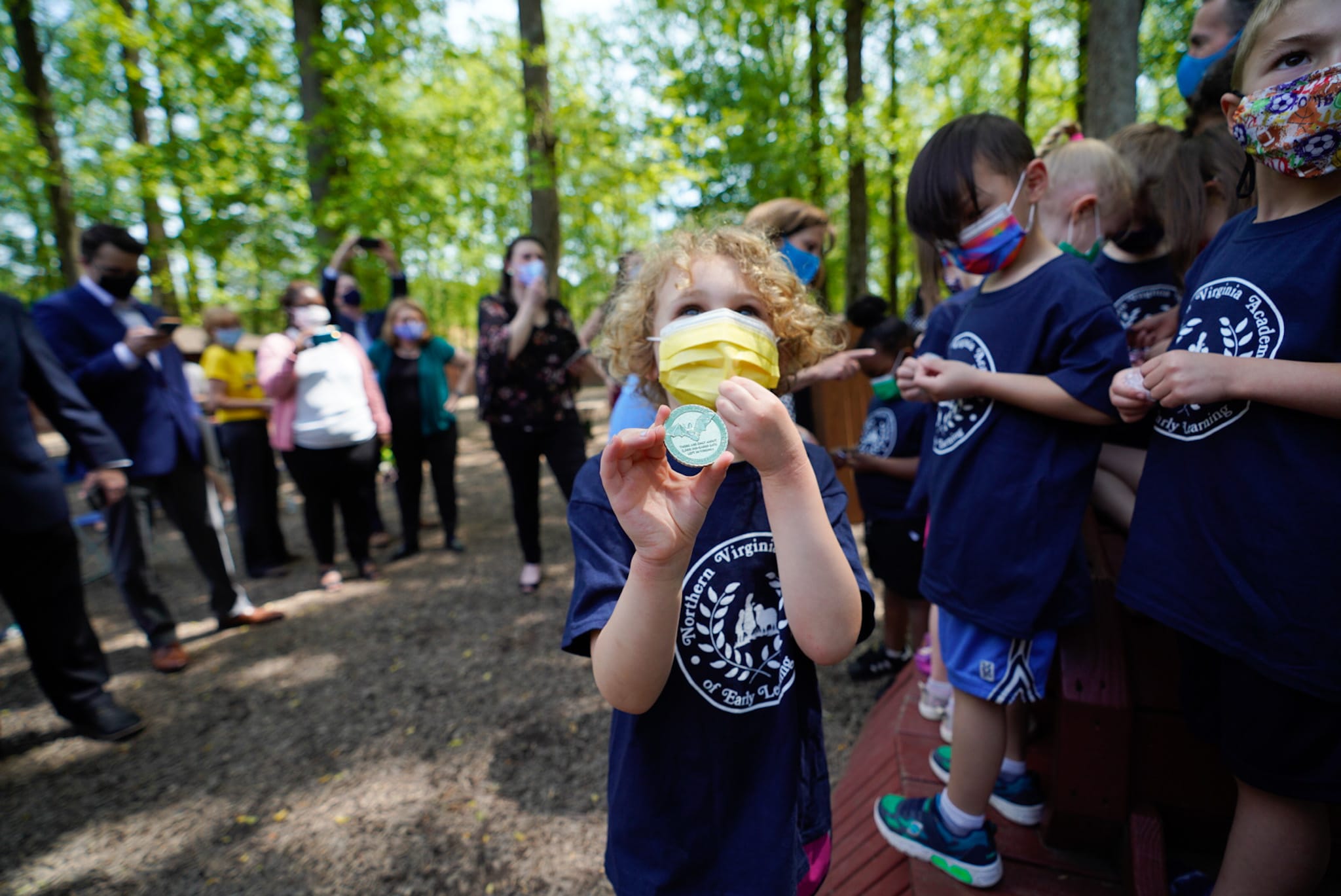 A student at the same Burke, VA child care center displaying the first lady's challenge coin, which features Virginia native speciesA student at the same Burke, VA child care center displaying the first lady's challenge coin, which features Virginia native species